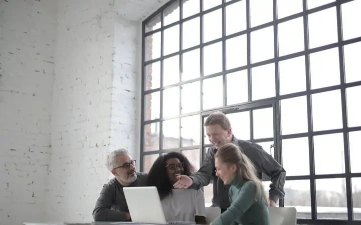 A small software team gathered around a laptop