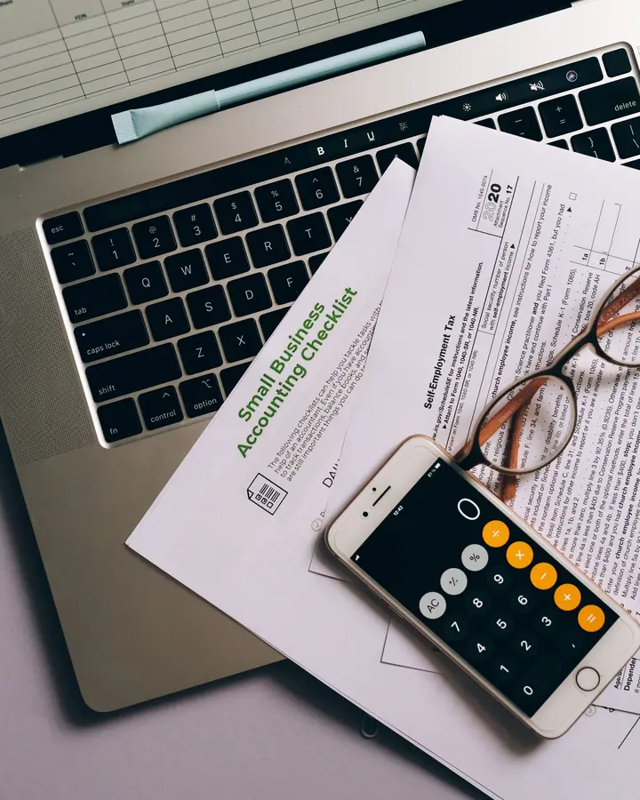 A laptop, paperwork and a phone on a small-business desk